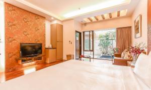 1 dormitorio grande con 1 cama grande y TV en Yage Hotspring House en Jiaoxi