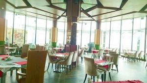 Regalia Suites Infinity Pool Kuala Lumpur في كوالالمبور: غرفة طعام مع طاولات وكراسي ونوافذ