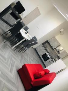 a living room with a red couch and a kitchen at Il Quarzo A) B) in Càbras