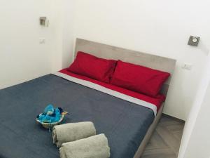 a bed with a red pillow and a blue bird in a basket at Il Quarzo A) B) in Càbras