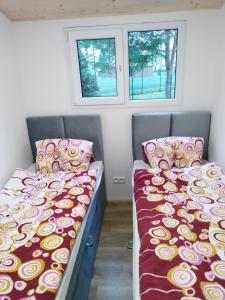 - 2 lits dans une petite chambre avec 2 fenêtres dans l'établissement Domek Kormoran, à Jarosławiec