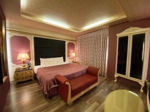 1 dormitorio con 1 cama y 1 silla en Hua Xiang Motel, en Kaohsiung