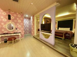 1 dormitorio con 1 cama y TV en una habitación en Hua Xiang Motel, en Kaohsiung