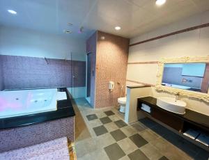 a bathroom with a tub and a sink and a toilet at Hua Xiang Motel in Kaohsiung