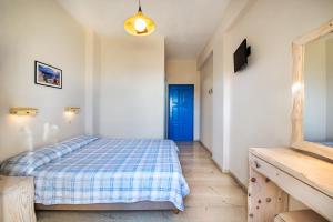 
a bedroom with a bed and a desk at Anatoli Hotel in Fira
