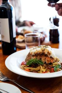 a plate of food on a table with a bottle of wine at Eiger Chalet in Perisher Valley