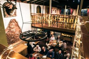 a group of people sitting at tables in a restaurant at Eiger Chalet in Perisher Valley