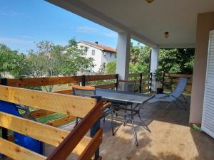 patio con mesa y sillas en el balcón en Holiday House Elena en Fažana