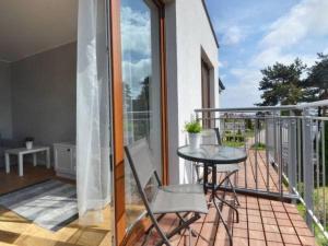 eine Terrasse mit einem Tisch und Stühlen auf dem Balkon in der Unterkunft Apartament Biały in Władysławowo