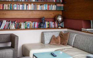 a couch in a room with a book shelf with books at Apartment-Hotel Schaffenrath in Salzburg