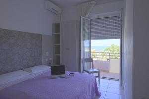 1 dormitorio con 1 cama con ordenador portátil en Hotel Ridens, en Rímini