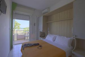 Habitación de hotel con cama y balcón en Hotel Ridens en Rímini