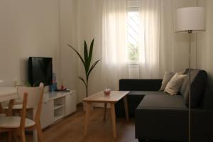 - un salon avec un canapé et une table dans l'établissement Apartamentos Apartour Bormujos, à Bormujos