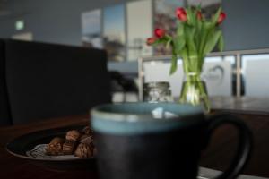 een kop koffie en een bord chocolateuts op een tafel bij Hotel Friheden in Allinge