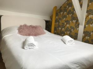 ein Bett mit zwei Handtüchern und zwei Kissen darauf in der Unterkunft Deauville Triangle d OR in Deauville + 24 Fotos