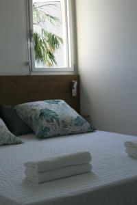 a bed with two towels on it with a window at Mare e Vista in Ajaccio