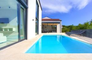 a swimming pool in the backyard of a house at Casa Bela in Klimno