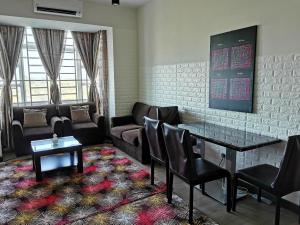 a living room with a couch and a table and chairs at Ilham Homestay @ Anjung Vista Kubang Kerian in Kota Bharu