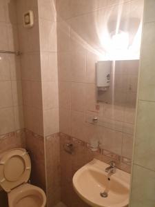 a bathroom with a toilet and a sink at Квартири СЪН in Nesebar +50 photos