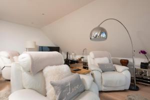 a living room with two white chairs and a lamp at Fistral beach Penthouse, Newquay in Crantock