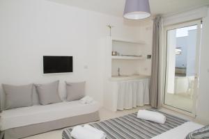 a white living room with a couch and a tv at Dimora Ausentum in Torre San Giovanni Ugento