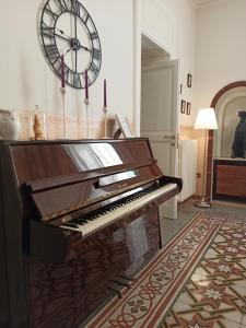 a piano in a room with a clock on the wall at Luciano And Son in Campobasso