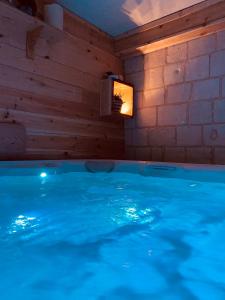 a swimming pool in a room with blue water at Ferme Des Chartroux in Maresville