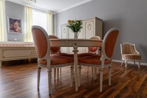 a dining room table with chairs and a vase of flowers at Penzion Florián Telč in Telč
