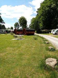 un parque con dos grandes barriles en la hierba en Campingplatz Aichelberg, en Aichelberg