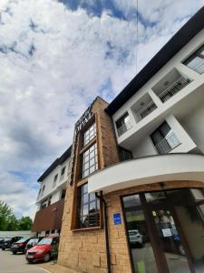 a large building with windows and a clock on the side of it at Hotel Opal Exclusive Bihać in Bihać