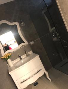 La salle de bains est pourvue d'un lavabo et d'un miroir. dans l'établissement Apartment Luxury, à Râmnicu Vâlcea