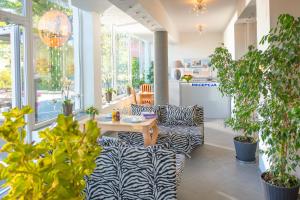 Zimmer mit Pflanzen, einem Tisch und Stühlen in der Unterkunft Murena Hotel i Restauracja in Ustronie Morskie