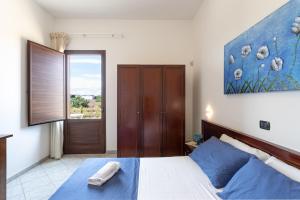 a bedroom with a bed with blue pillows at Agriturismo "Lu Puzzu" in Torre Lapillo