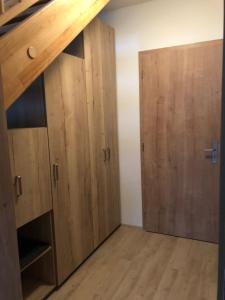 a room with wooden cabinets and ajar doors at Sport Apartmán DM in Dolní Morava