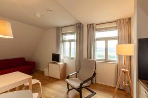 a living room with a red couch and a chair at Brand-Baude in Hohnstein