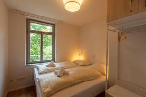 ein Schlafzimmer mit einem Bett mit zwei Kissen und einem Fenster in der Unterkunft Brand-Baude in Hohnstein