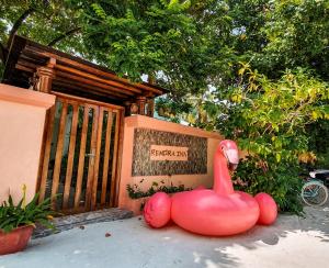 a large pink rubber duck statue in front of a building at Remora Inn in Faafu