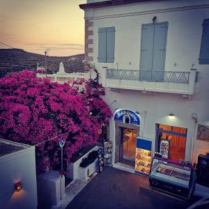 a building with pink flowers on the side of it at The little bougainvillea house in Kýthira