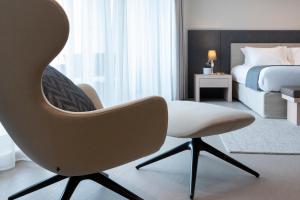 a bedroom with a white chair and a bed at Waterfront in Sliema