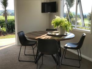 a dining room with a wooden table and chairs at Maungatautari Outlook Cambridge in Cambridge