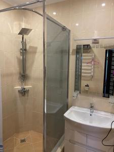 uma casa de banho com um chuveiro e um lavatório. em Міні-готель "Кімната Комфорт" em Odessa