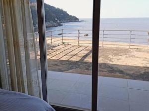 a bedroom with a view of the beach from a window at 馬港驛站 Oldharbor Hostel in Nangan