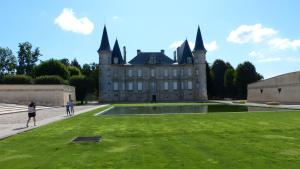 um castelo com pessoas de pé na relva em frente a ele em UN HAVRE DE PAIX DANS LES PINS SOULACAIS em Soulac-sur-Mer