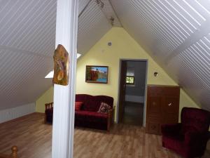 uma sala de estar com um sofá vermelho num sótão em Dwór Komorowo em Komorowo
