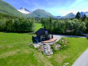 une petite cabine dans un champ avec des montagnes en arrière-plan dans l'établissement Heinåli Hytta, à Isfjorden