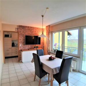 cocina y comedor con mesa y sillas en Ferienwohnung Taubertal Ferienhof Arold, en Creglingen