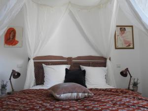 a bedroom with a bed with a canopy at Villa Madura in Saint-Michel-Chef-Chef