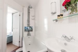 a white bathroom with a tub and a sink at The Royal Harbour Hotel in Ramsgate