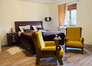 a bedroom with a bed and a yellow chair at Zvjezdana dolina Garni hotel in Andrijevica