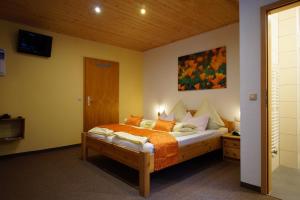 1 dormitorio con 1 cama y una pintura en la pared en Gasthof Pension Waldfrieden en Brand